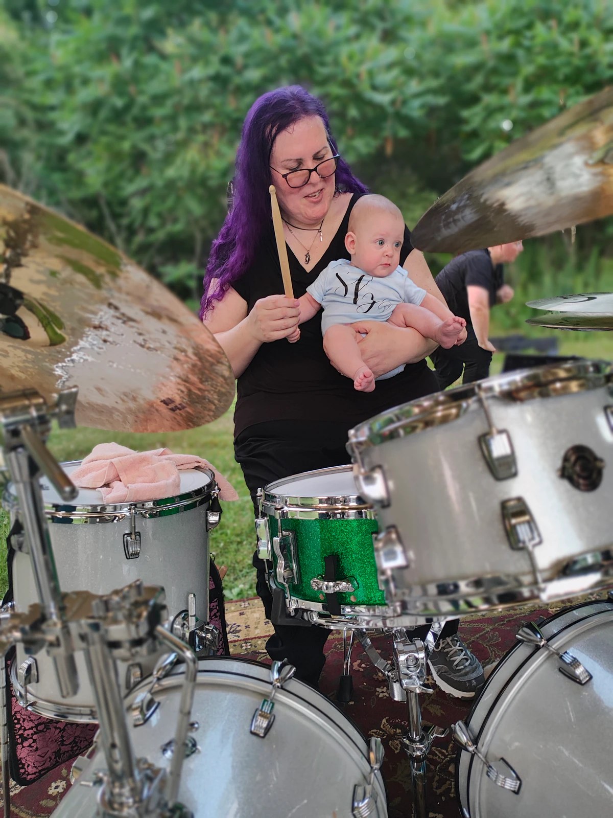 Penny Larson playing drums outdoors