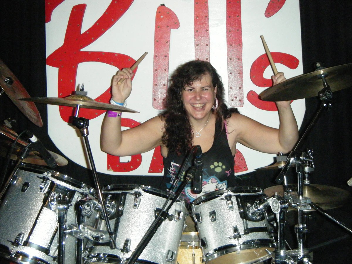 Penny Larson performing live on drum set